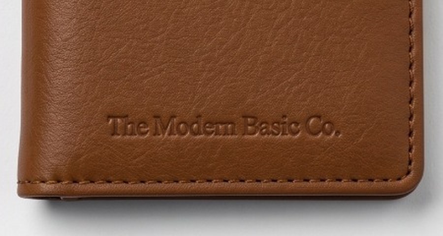 A close-up of the wallet's vegan-leather face, with The Modern Basic Co. emboss