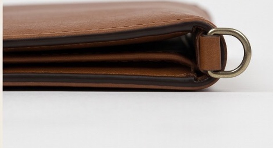 The wallet's burnished edge profile with a brass D-ring
